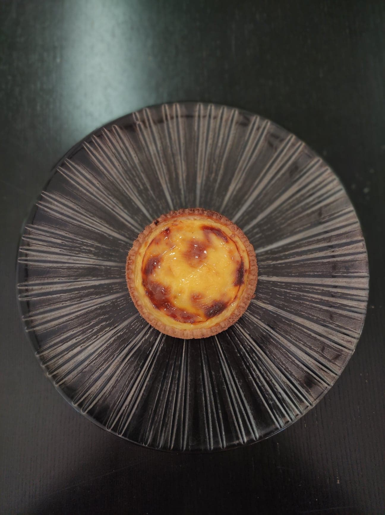 Un flan pâtissier disposé au centre d'une assiette.