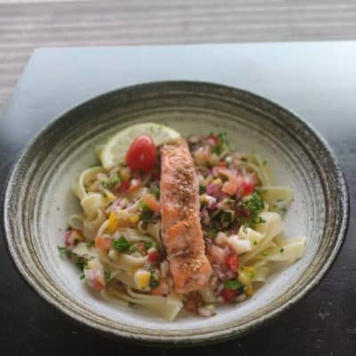 Un assiette de tagliatelles et petits légumes, avec un joli pavé de saumon.