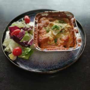 Plat de lasagnes au saumon accompagné d'une salade verte.